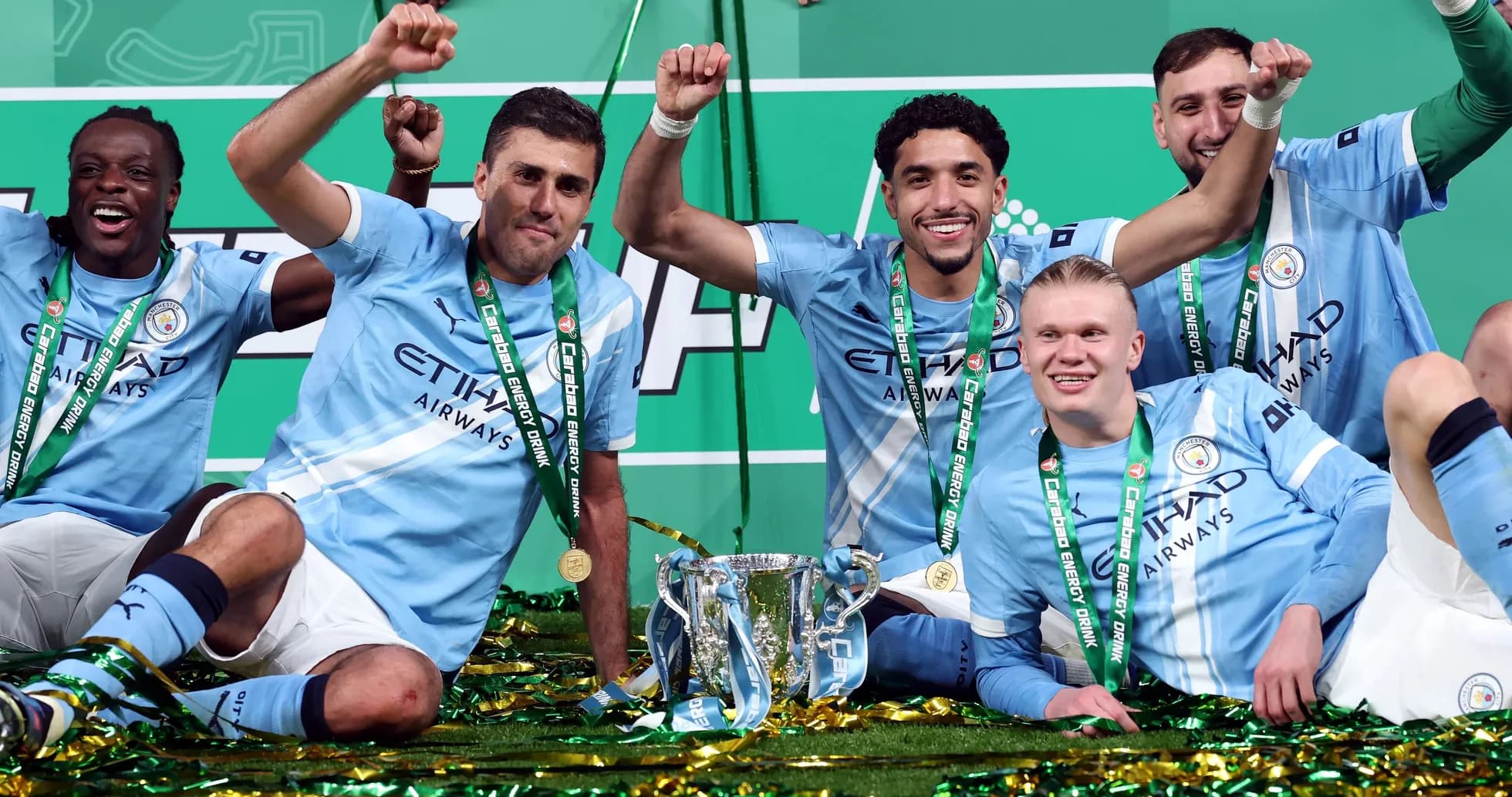 Manchester City players celebrating with trophy and medals