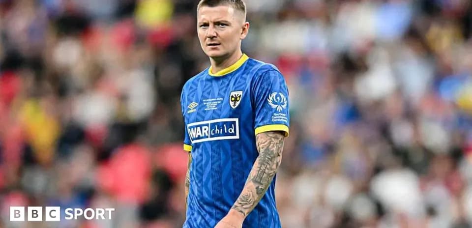 Player in blue kit during match at stadium