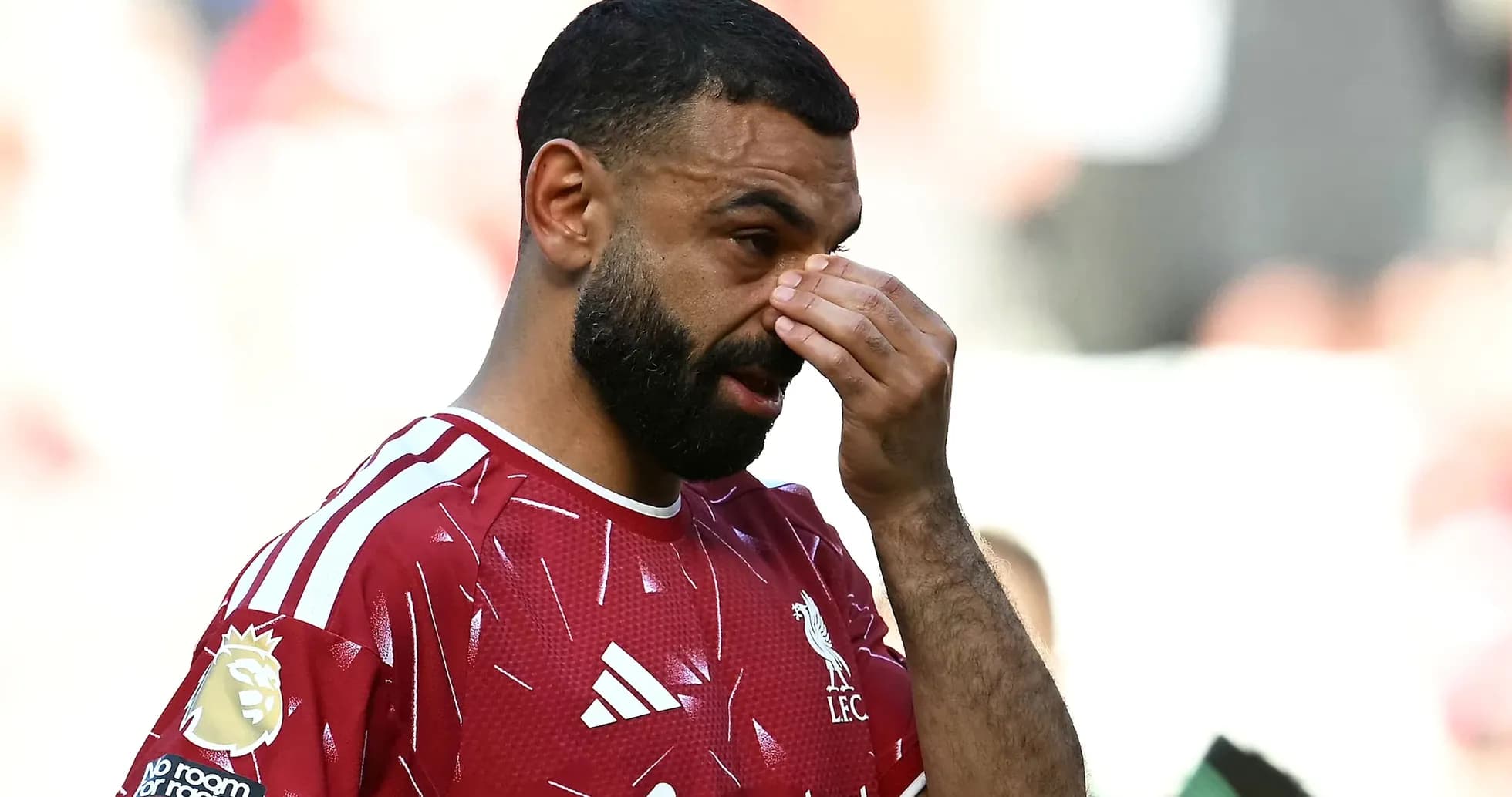 Player in Liverpool jersey touching his face