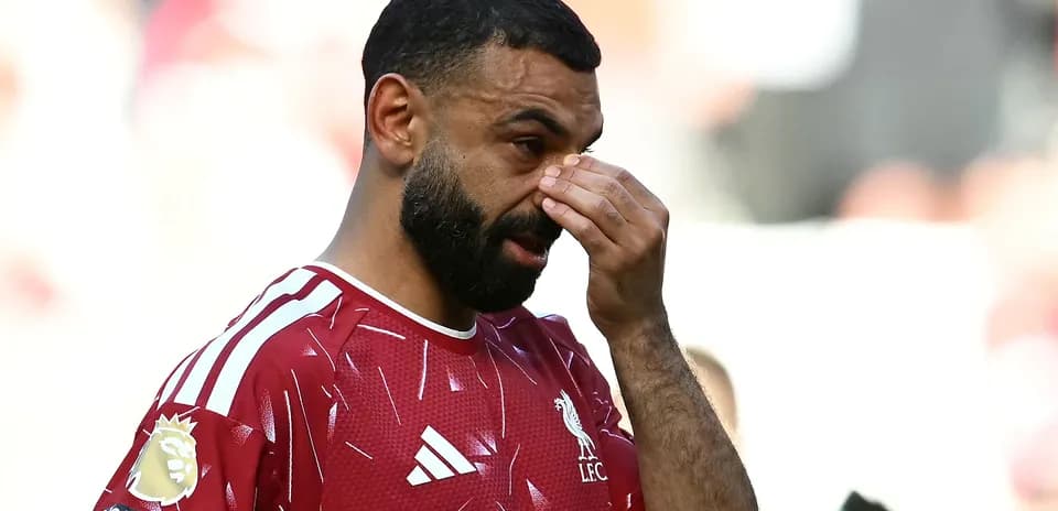 Player in Liverpool jersey touching his face