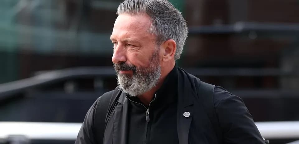 Man with beard walking past a bus