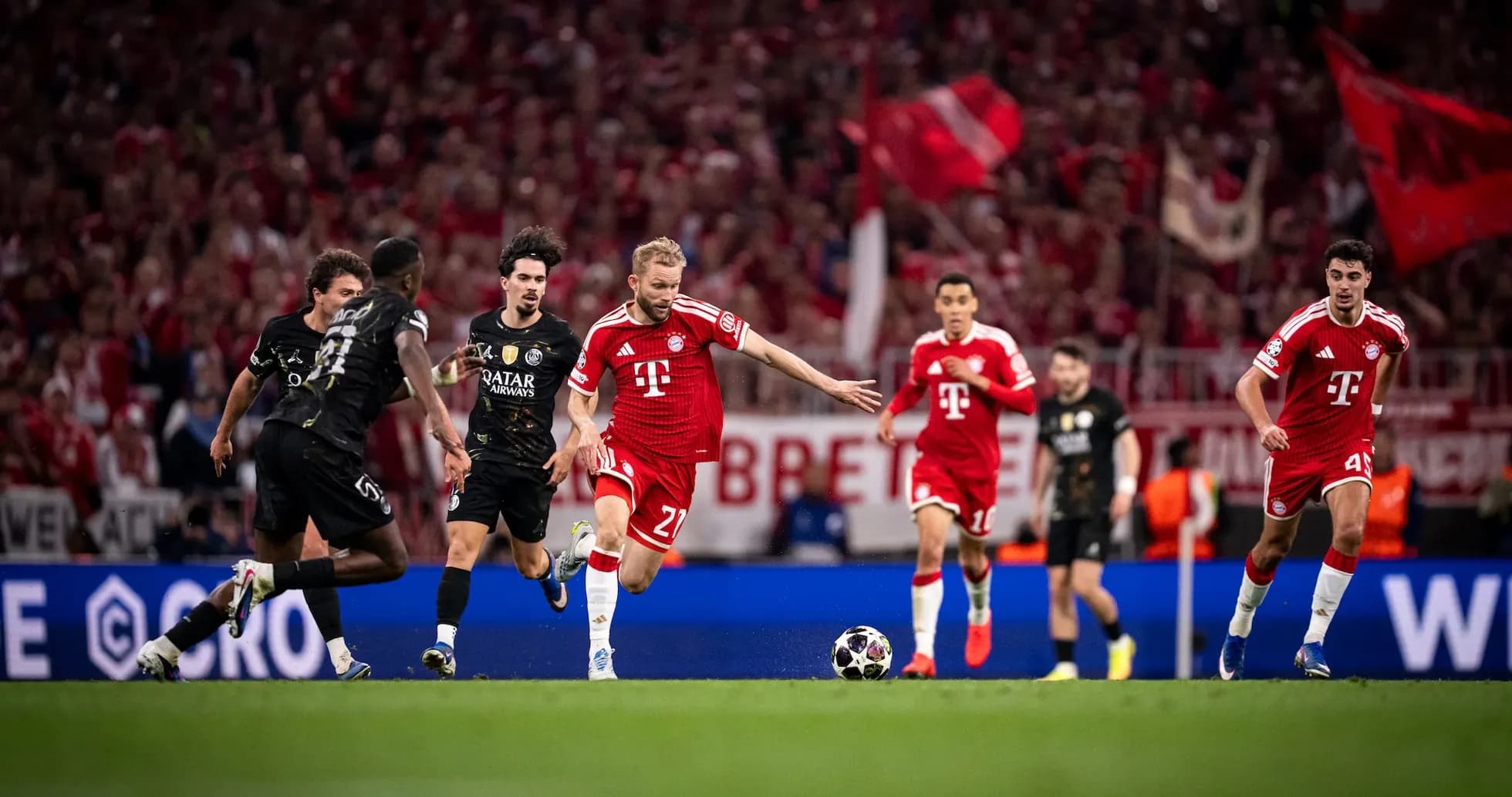 Bayern player dribbling against PSG defenders