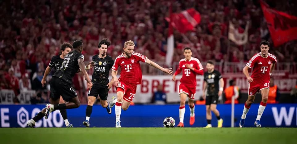 Bayern player dribbling against PSG defenders