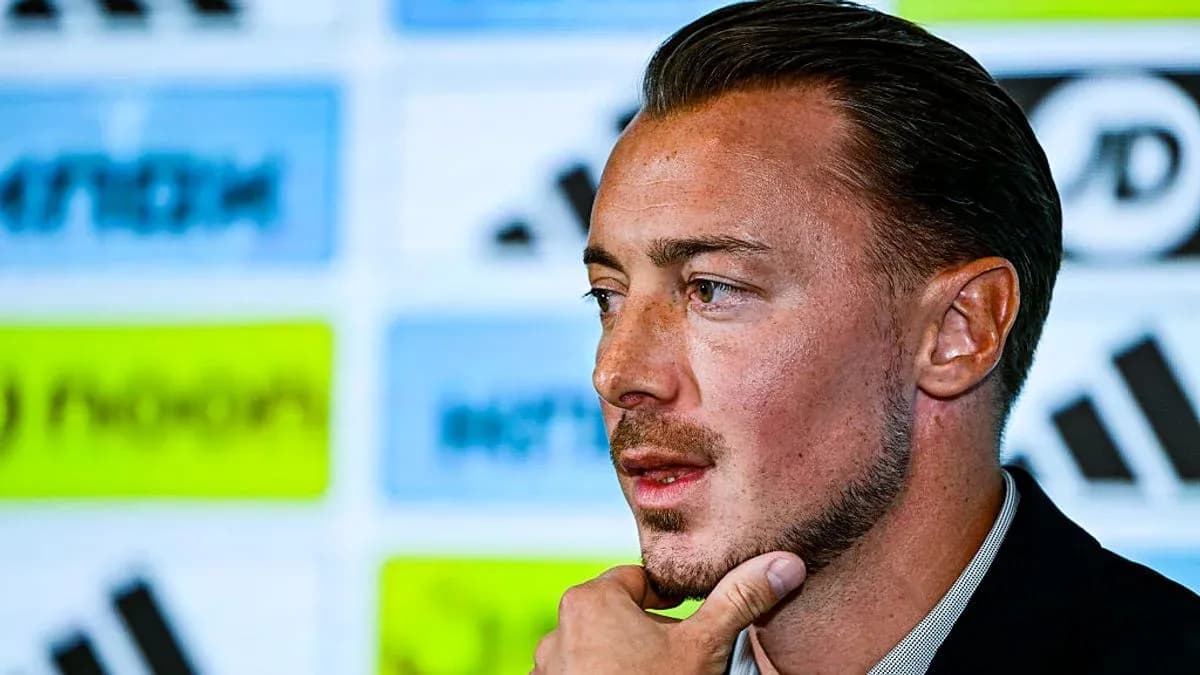 Man speaking at a press conference with logos behind