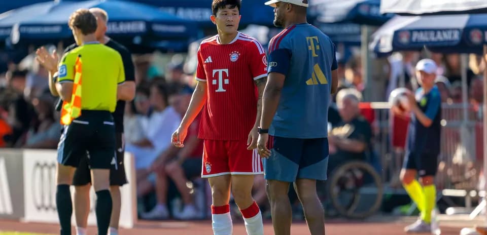 Bayern Munich player speaking with coach during match