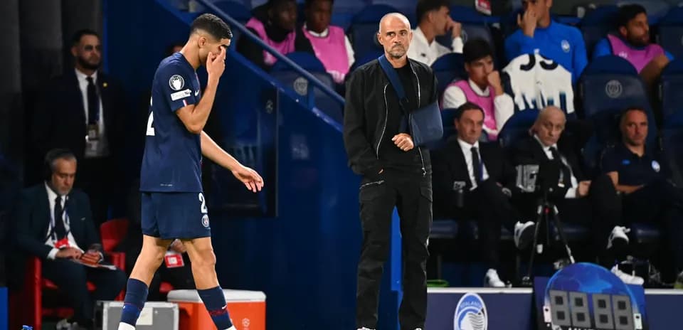 Player leaving the pitch with coach observing