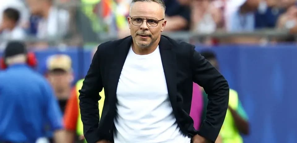 Coach walking along the sidelines during match