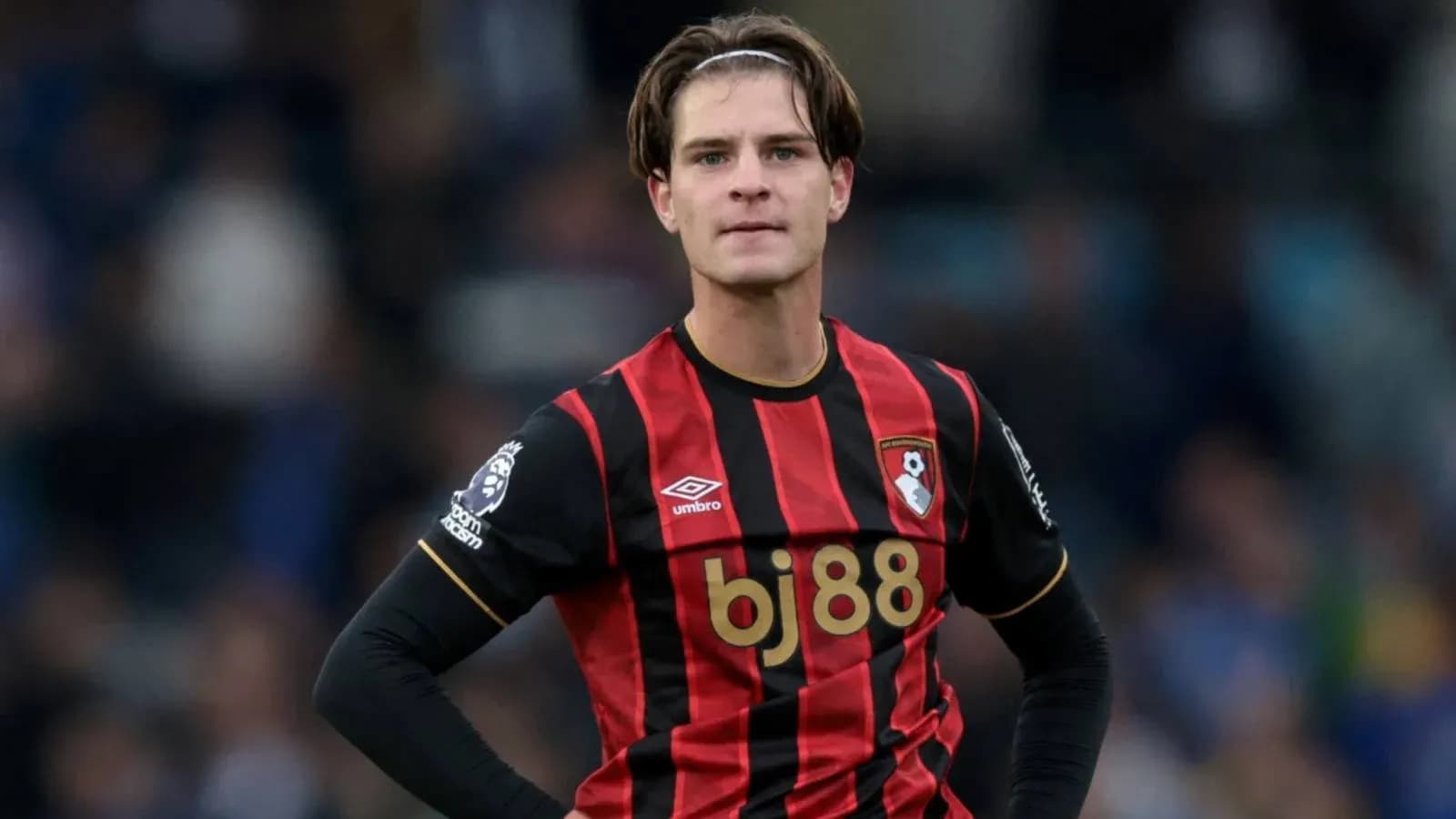 Bournemouth player in red and black jersey on pitch