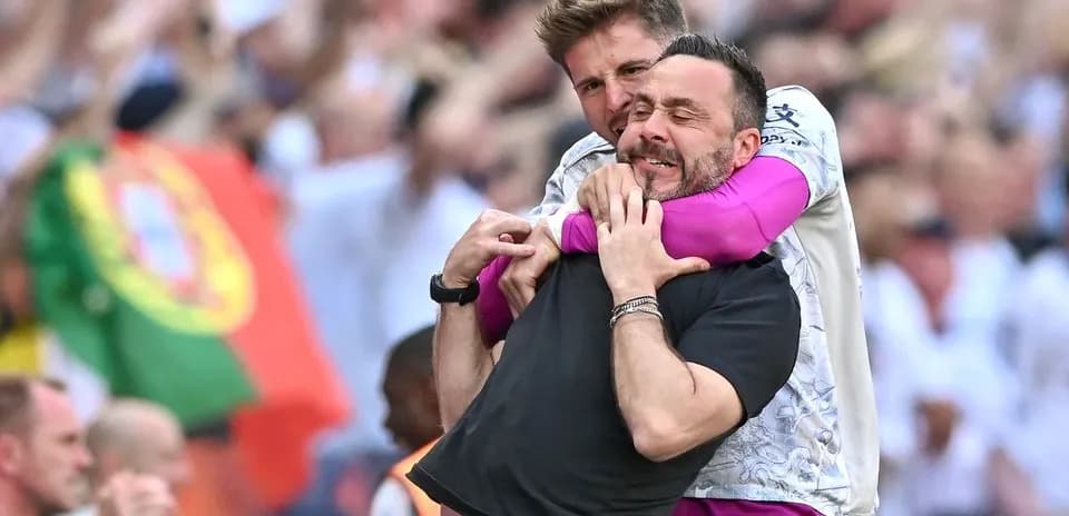 Two coaches celebrating an exciting moment together