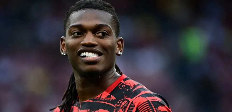 Player smiling in red patterned jersey during match