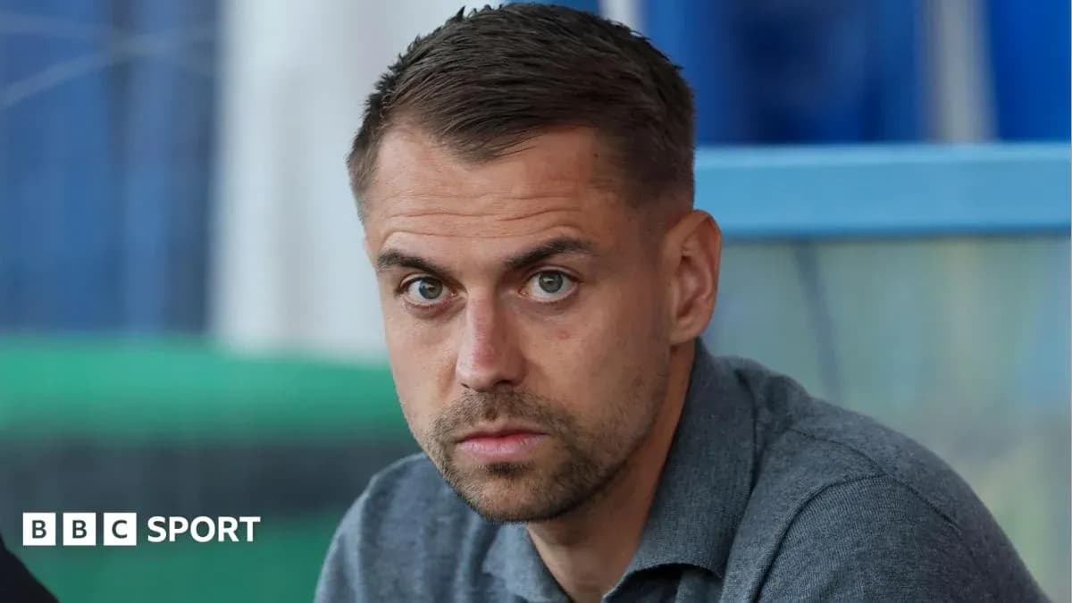 Man sitting in sports venue looking at camera