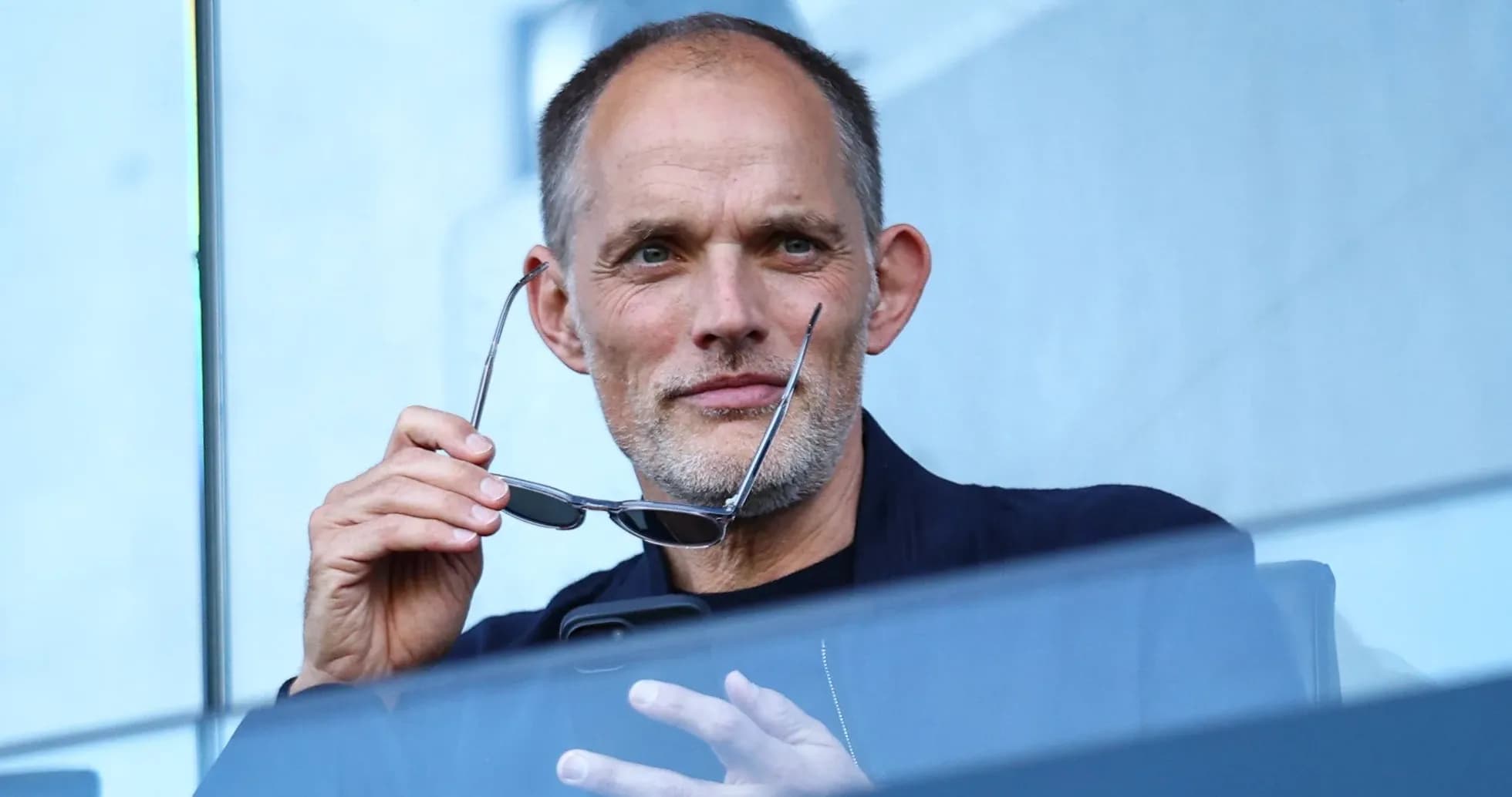 Man holding glasses while seated in a box