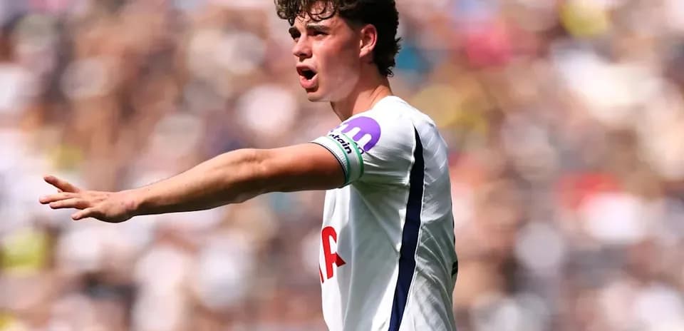 Player gesturing during match with Tottenham kit