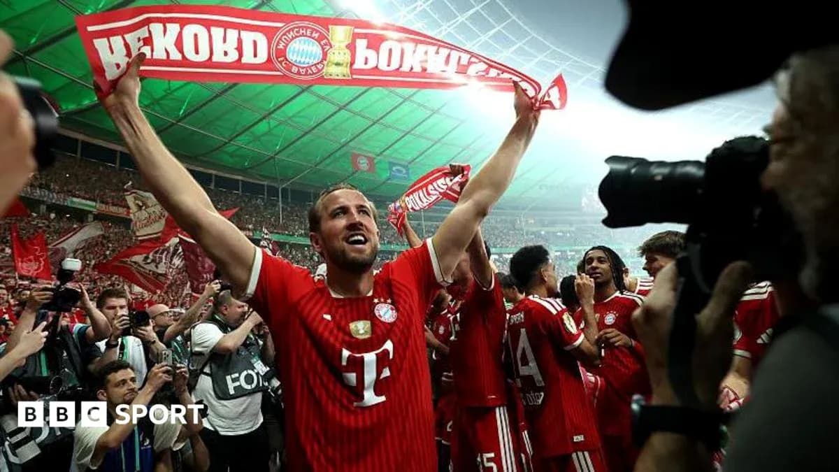 Player celebrating with fans and holding a banner