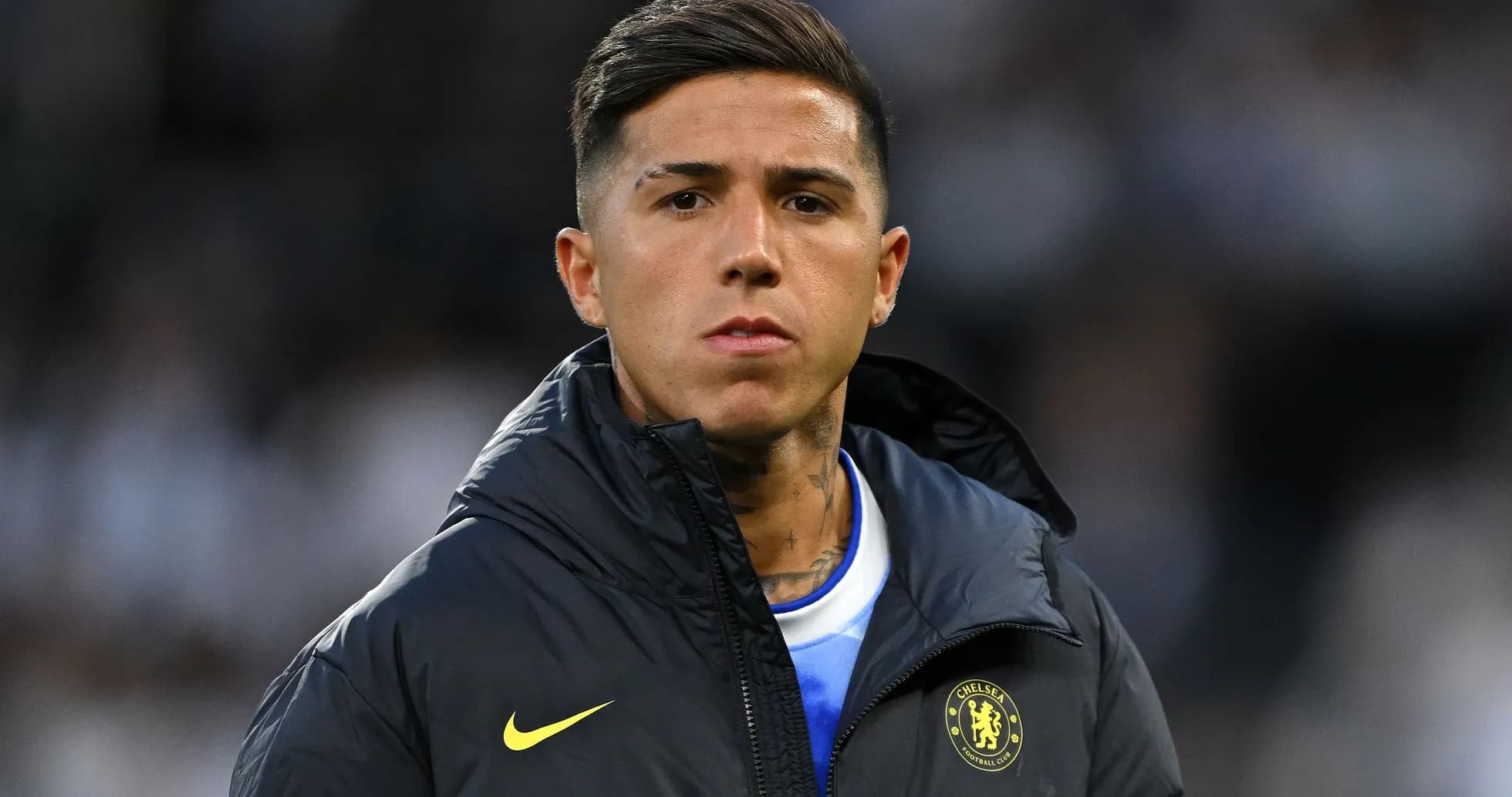 Player wearing Chelsea jacket on the sidelines