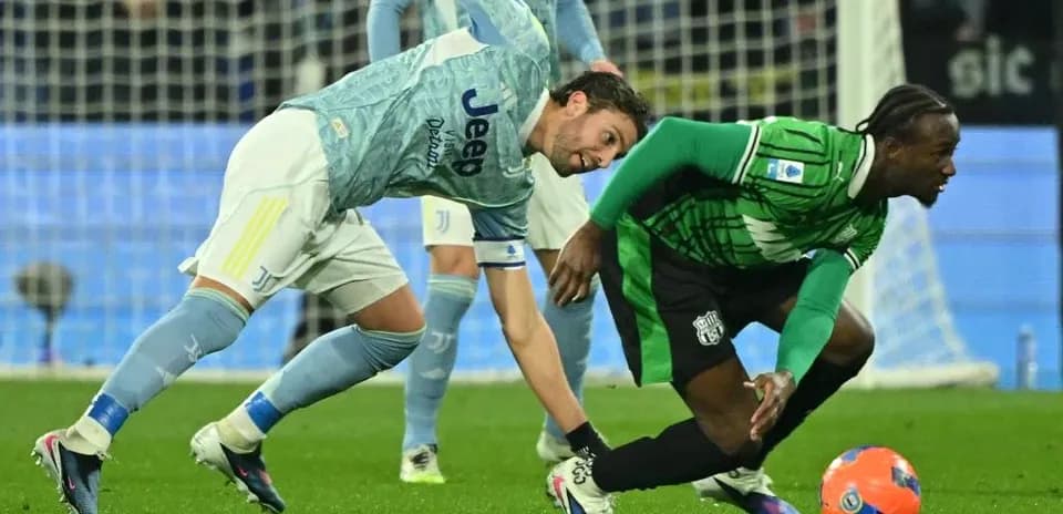 Sassuolo player challenging Juventus goalkeeper for the ball
