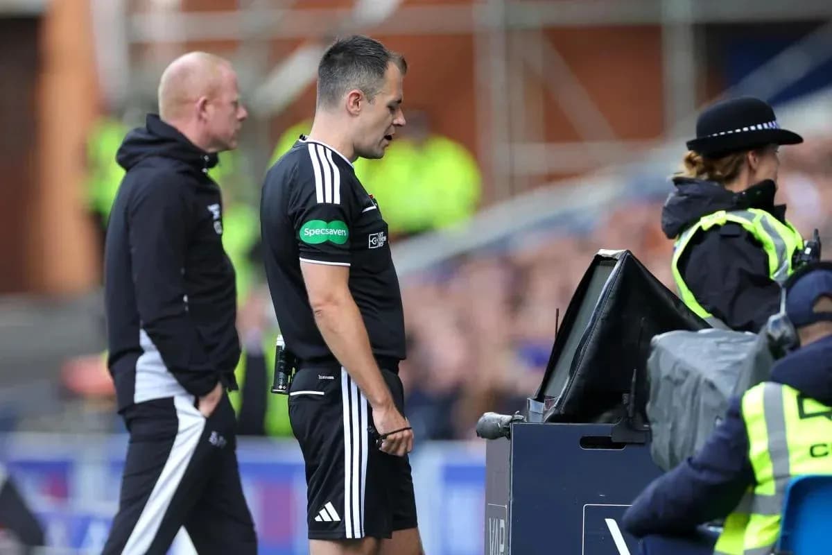 Referee reviewing decision at VAR monitor during match