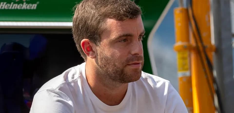 Man sitting near a racing team's garage