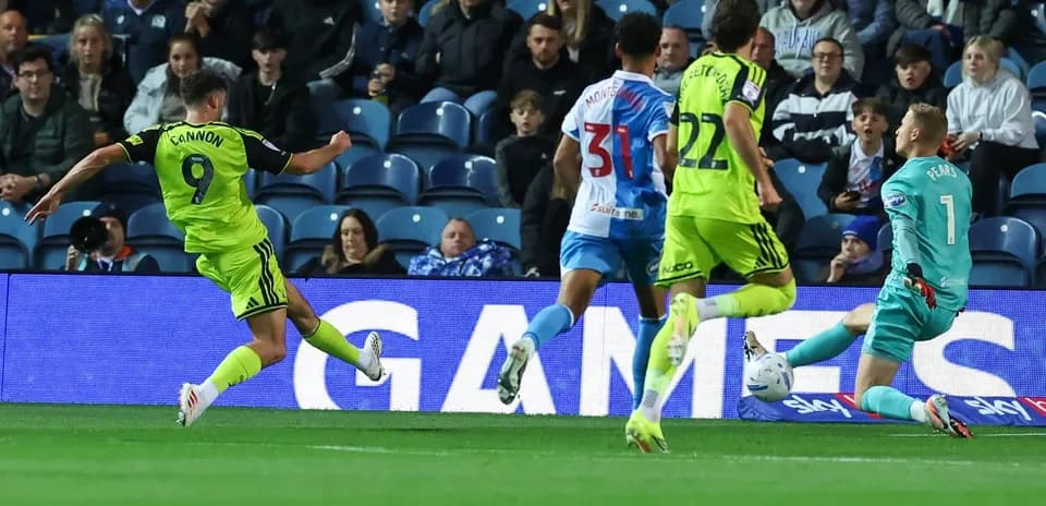 Player shooting towards goal during match action