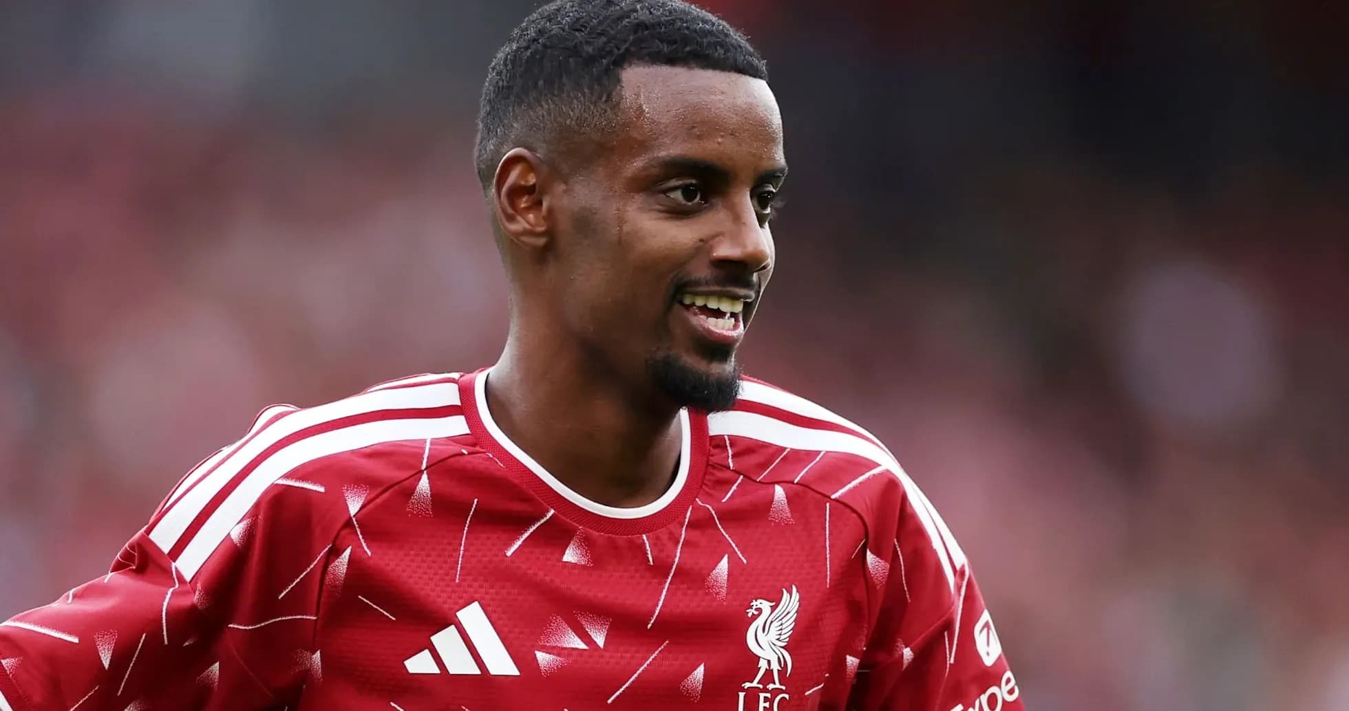 Player in Liverpool FC kit smiling on field