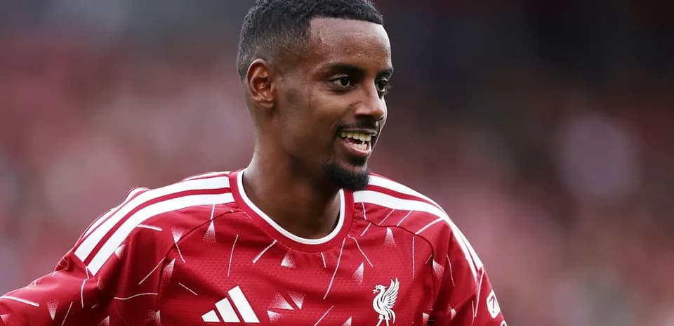 Player in Liverpool FC kit smiling on field