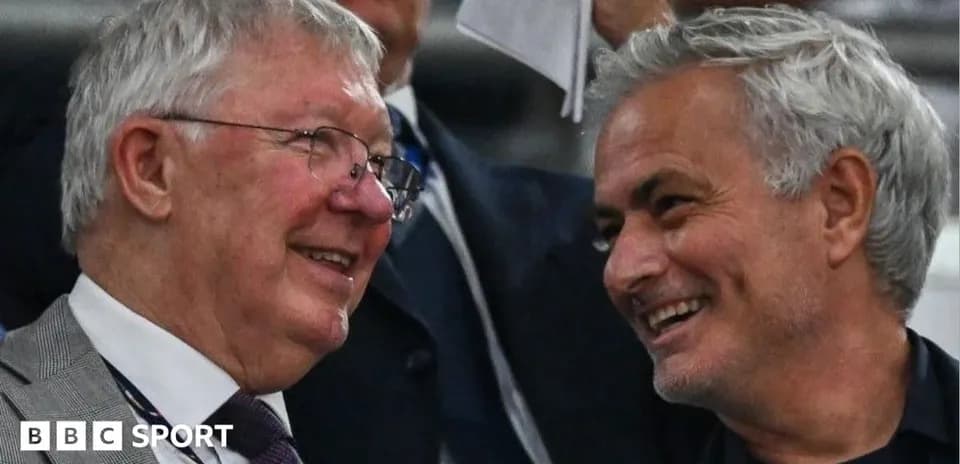 Two coaches smiling and conversing in stands