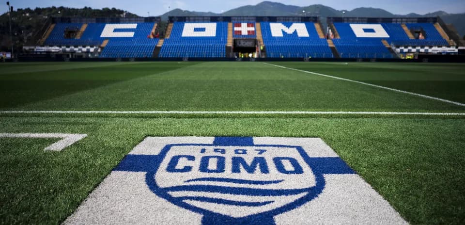 Como football stadium with club logo in foreground