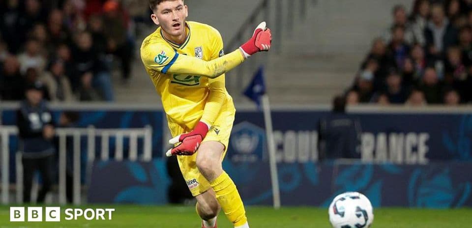 Goalkeeper in yellow kit playing the ball during match