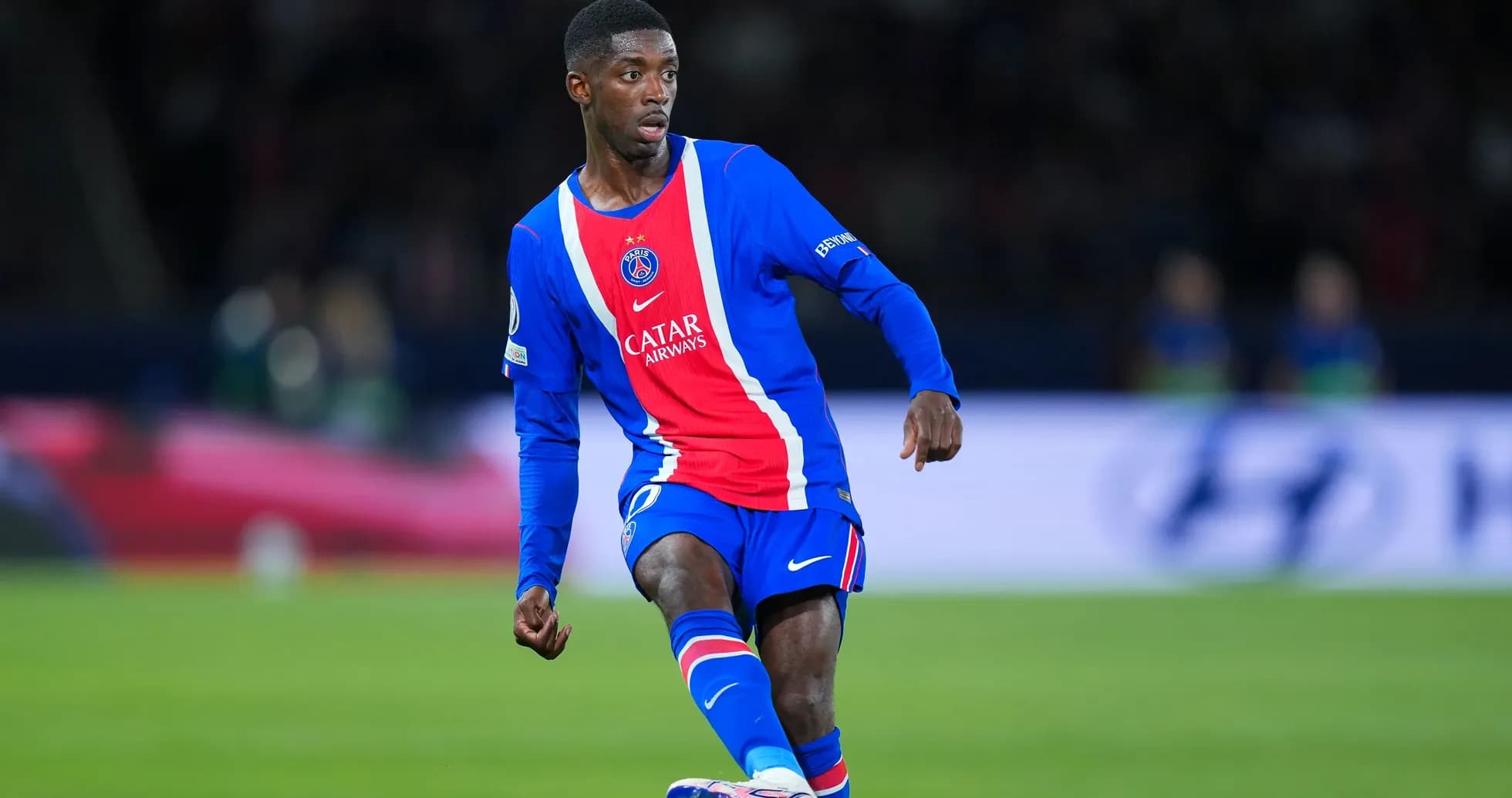 Player in PSG kit dribbling the ball on field