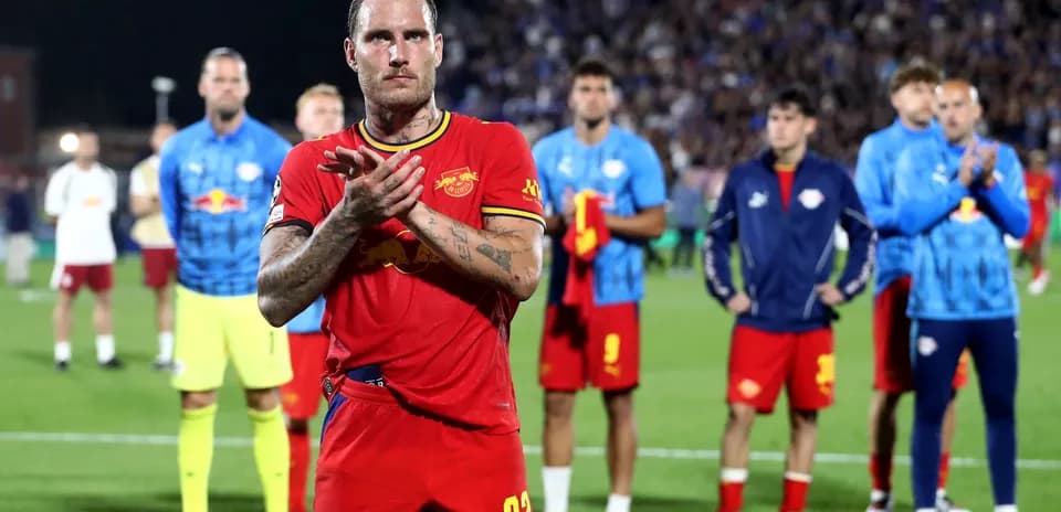 Player in red jersey applauding on the field
