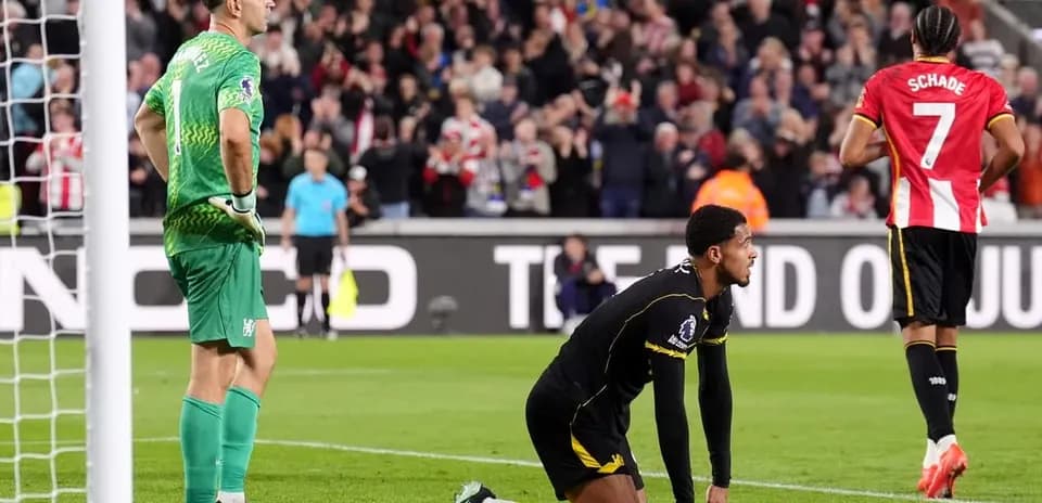Goalkeeper watching as player kneels on pitch