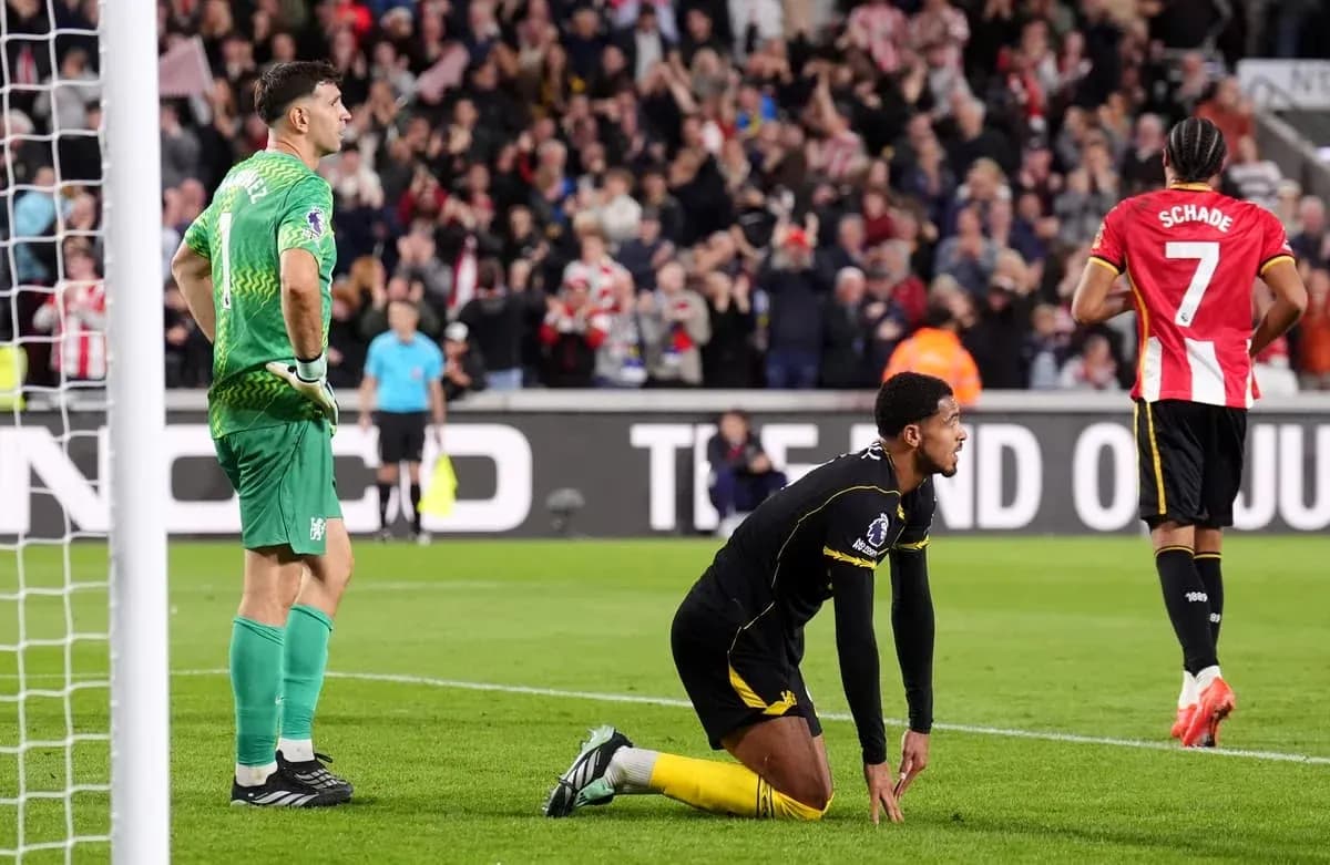 Goalkeeper watching as player kneels on pitch