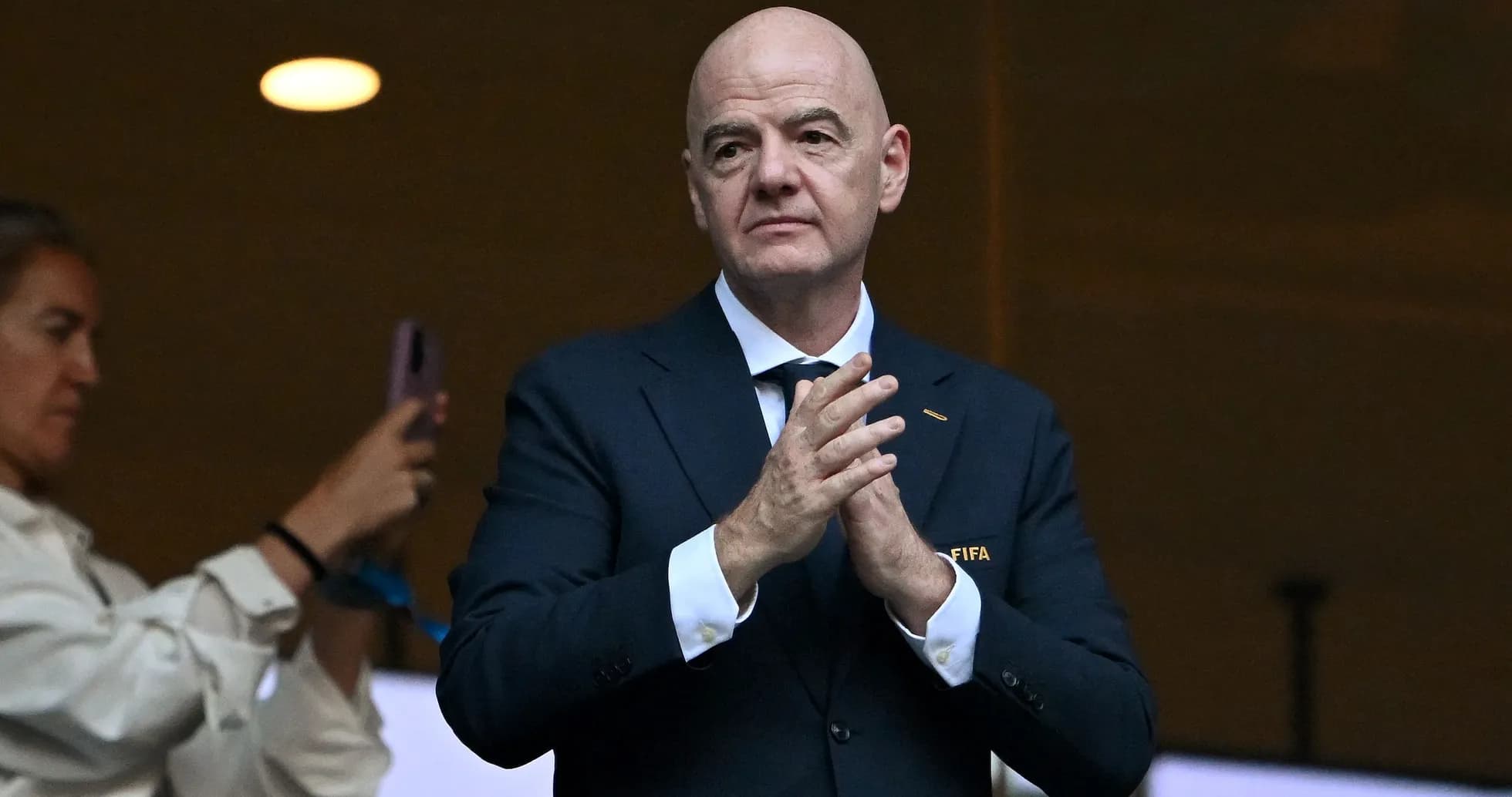 FIFA official applauding in a stadium box