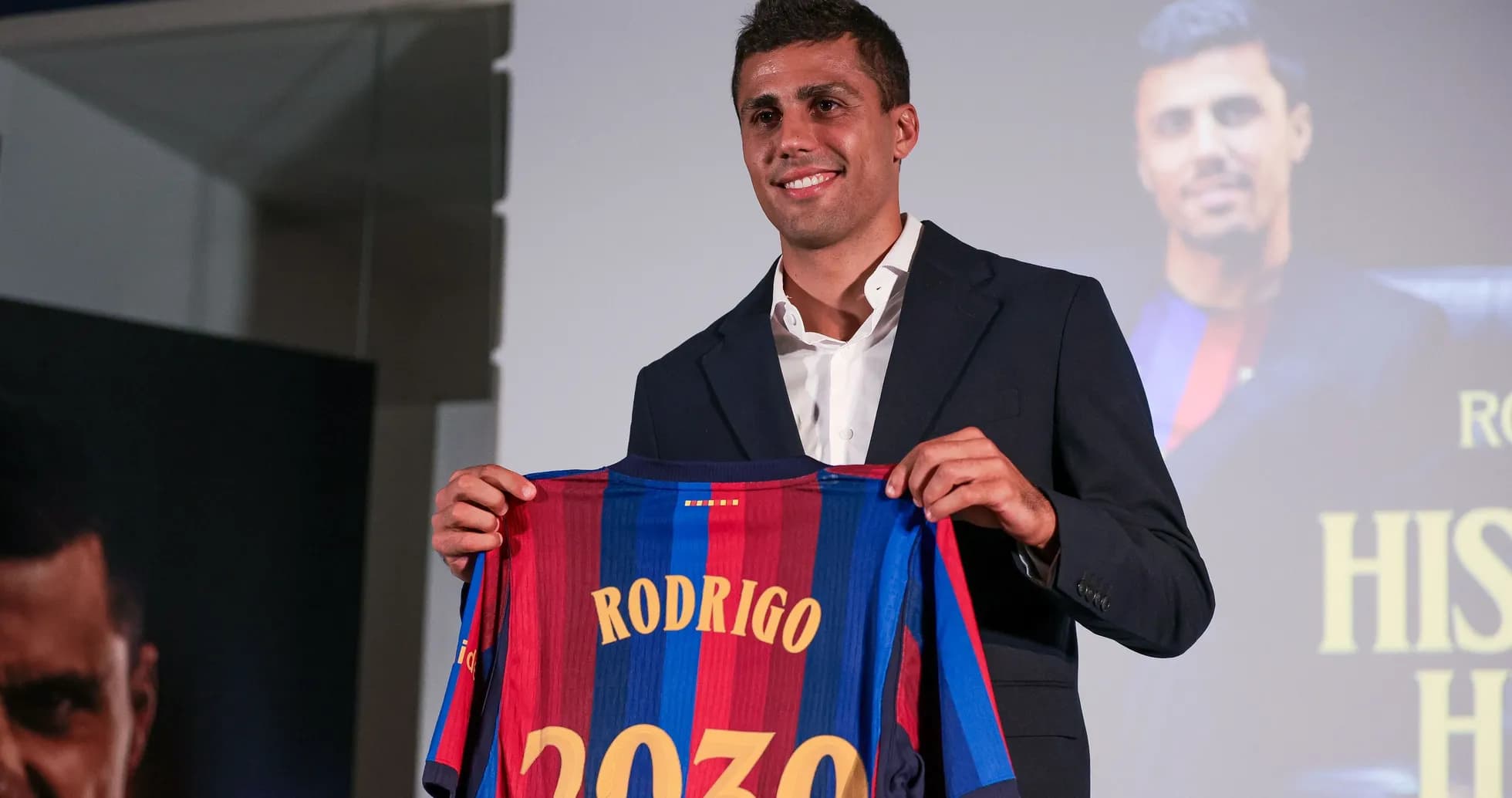 Player holding Barcelona jersey with 'Rodrigo 2030'