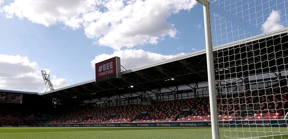 Goalpost with stadium and clouds in background