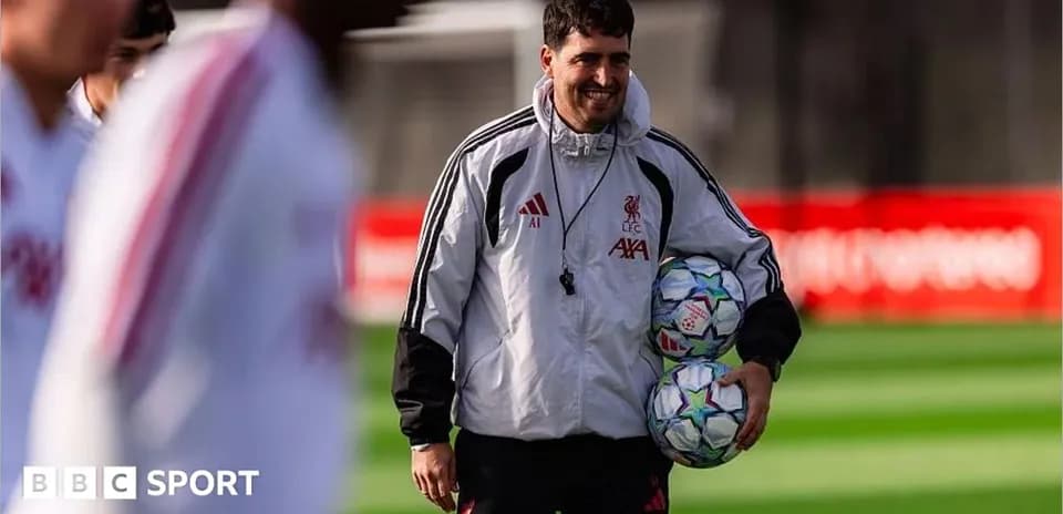 Coach holding footballs during Liverpool training session