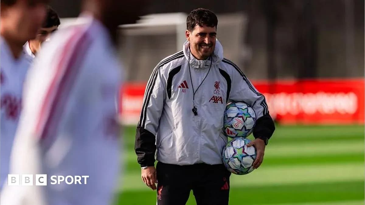 Coach holding footballs during Liverpool training session