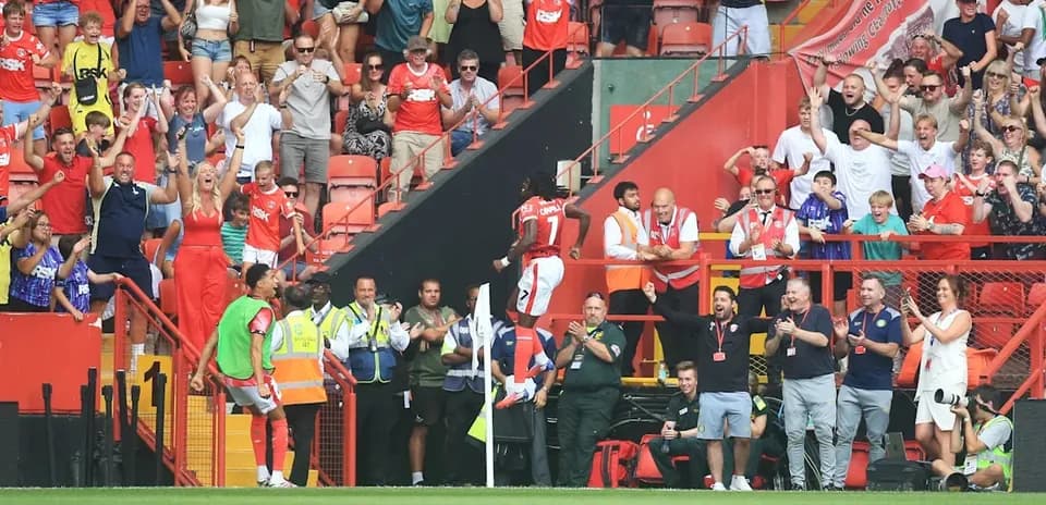 Players celebrating a goal with excited fans