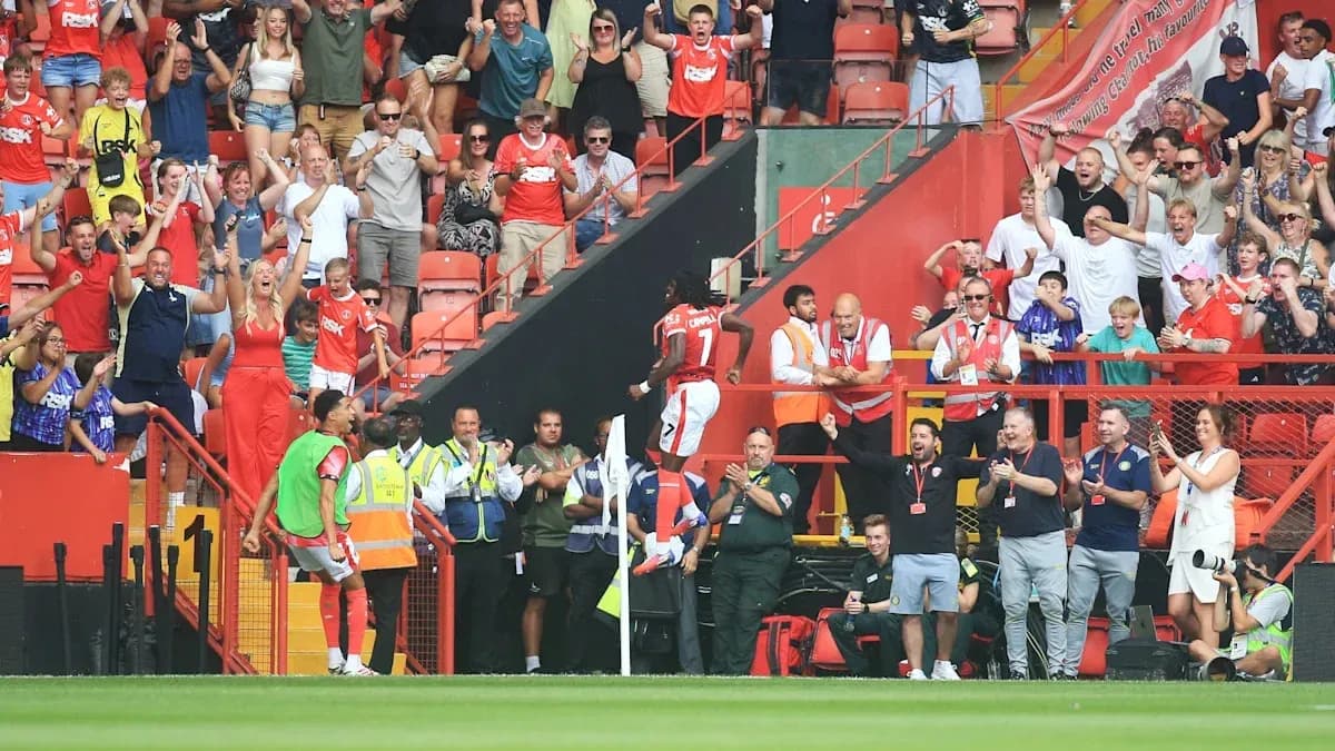 Players celebrating a goal with excited fans