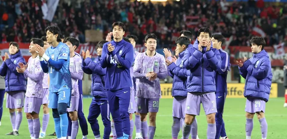Team in purple jerseys applauding fans after match