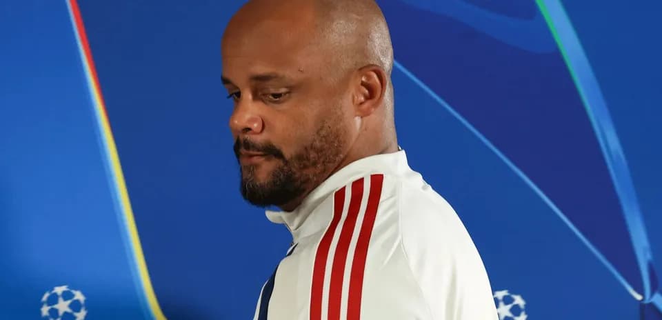 Coach walking past UEFA Champions League backdrop