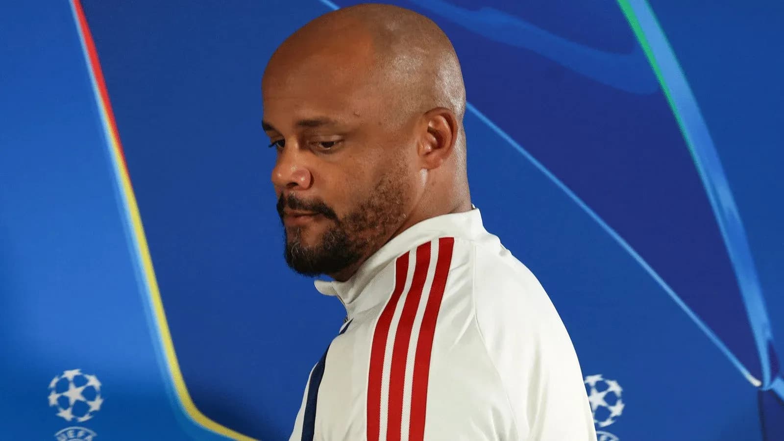 Coach walking past UEFA Champions League backdrop