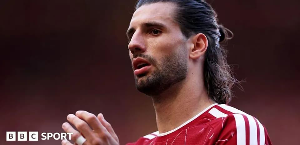 Player in red jersey preparing for the match