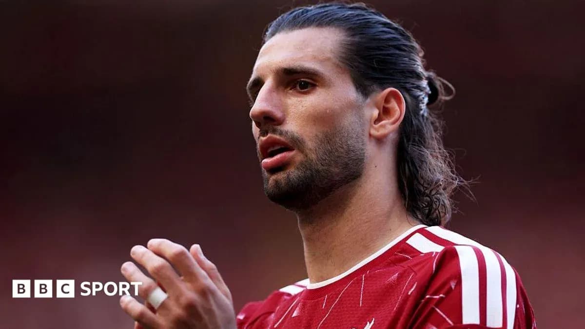 Player in red jersey preparing for the match