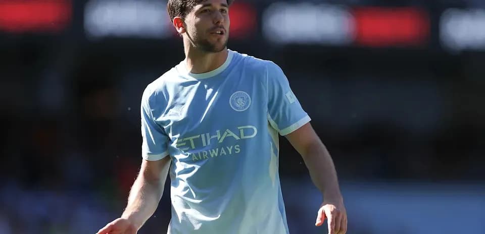 Player in light blue Manchester City jersey on pitch