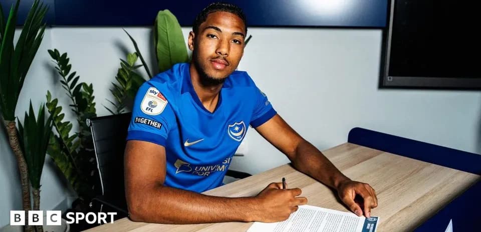 Player signing contract at a table with document