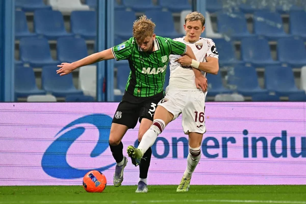 Sassuolo player challenged by Torino opponent