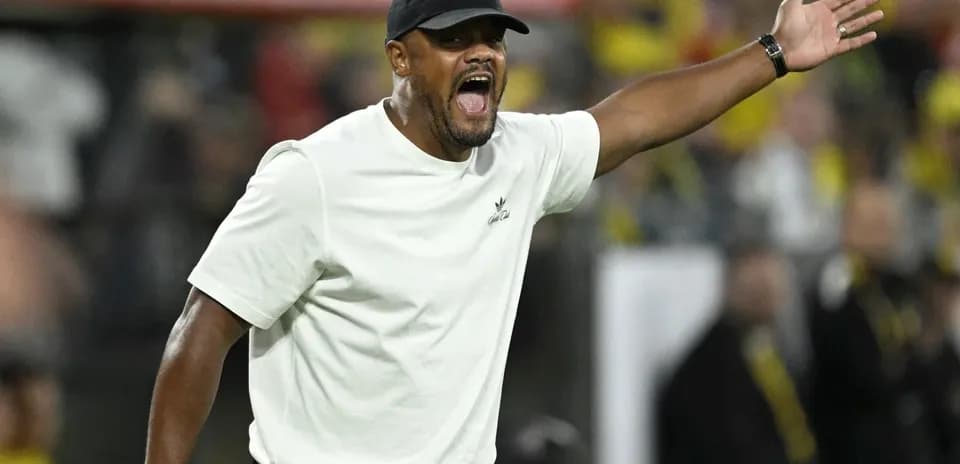 Coach gesturing during a football match on the sidelines