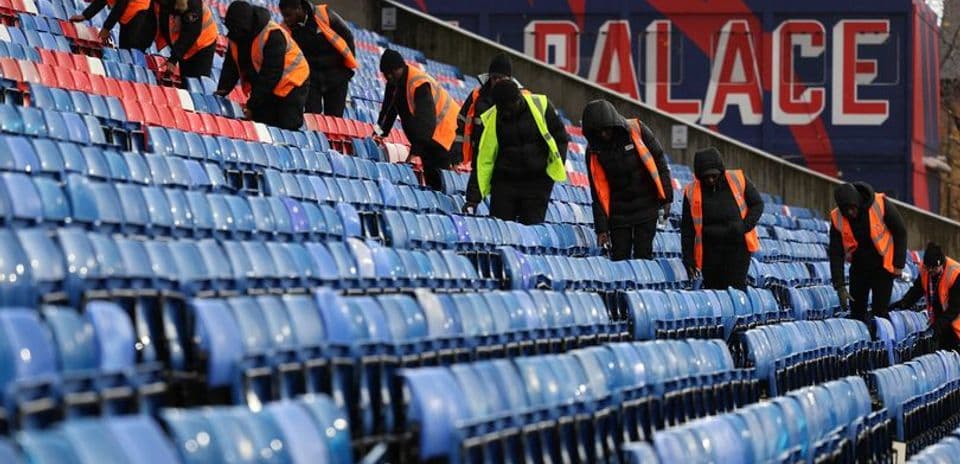 Workers cleaning seats in stadium stands