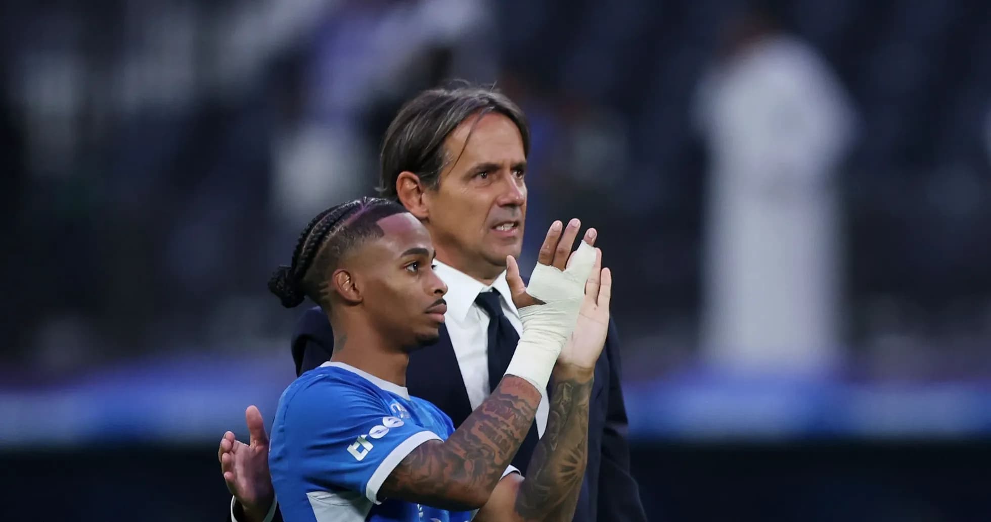 Player and coach interacting on the field post-match